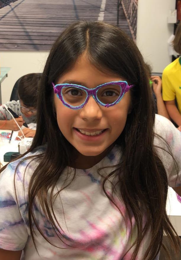 Criança a sorrir com os seus óculos 3D coloridos